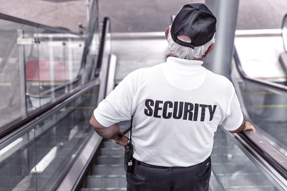 Security Mann auf einer Kaufhaus Rolltreppe